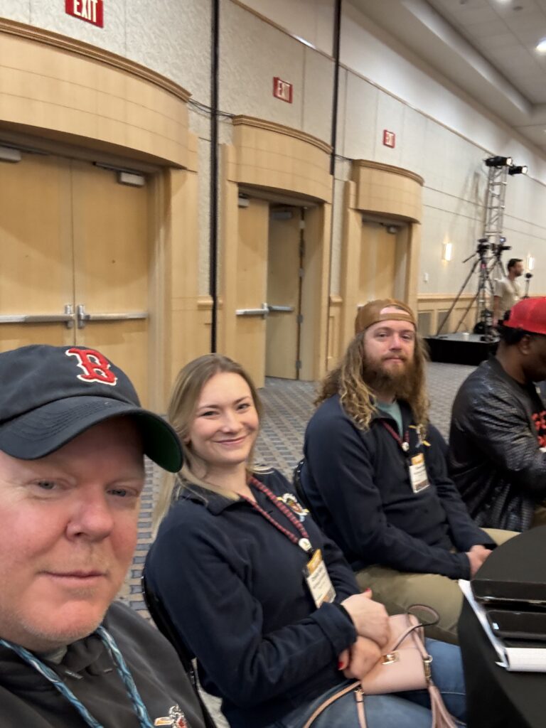 Jeremy, Chastity, and Derek seated next to each other in a conference room at the America Outdoors Conference.