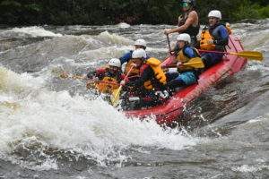 Group of 5 people and a guide whitewater rafting on the Dead River in Maine