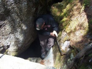 Man climbing along side ice cave wall in Maine