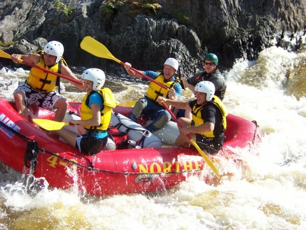 Group of people Rafting Through Choppy Water in Maine on a whitewater rafting trip