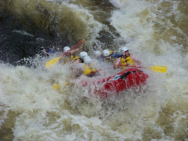Lots of whitewater surrounding a red raft on the Penobscot River in Maine