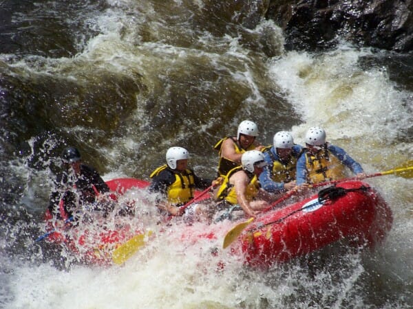 People rafting on the Penobscot River in Maine in a red raft