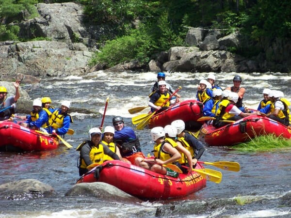 A group of four boats Whitewater Rafting on the Dead River